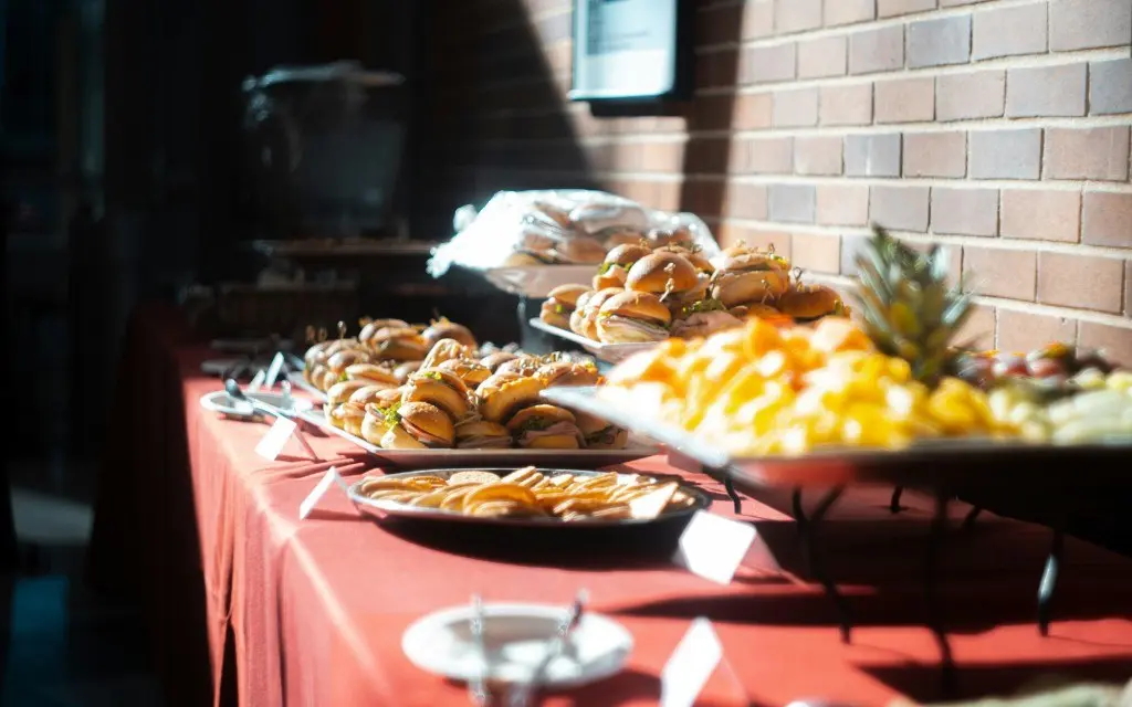 Catering table with sandwich platters, fruit, and crackers for a special event