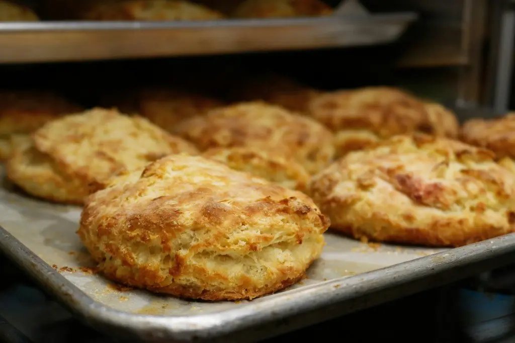 Golden flaky savoury scones fresh from the oven on a baking tray