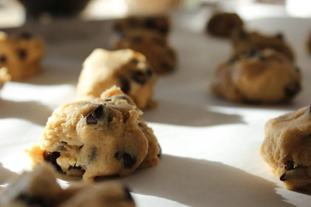 Chocolate chip cookie dough mounds on a baking tray